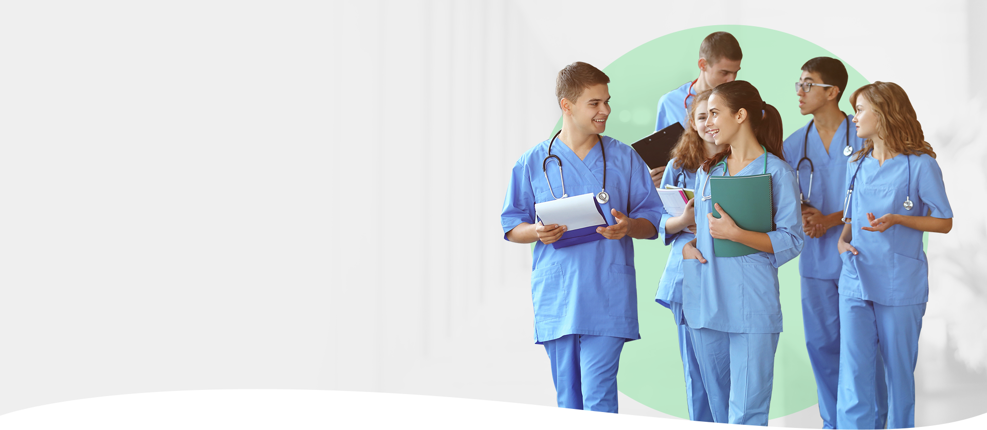 Medical students wearing scrubs discuss healthcare in a hospital hallway, highlighting training resources.